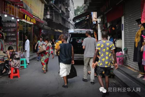 　　广州越秀区小北路靠近天秀大厦的天桥上人来人往，天桥下是车水马龙和远处耸立在灰霾中的高楼大厦。天桥的另一边，开往深圳的“和谐号”飞快地在铁轨上奔驰，发出巨大的噪音；铁轨下的桥洞里，小贩们正贩卖着各式的皮带、钱包、牛仔裤;理发的摊位上，剪刀“嚓嚓嚓”地响着。穿过桥洞，前面便是另外一个世界，一条只有短短几百米的街道。街道的名字叫宝汉直街，一处典型的城中村。图为穿过桥洞的非洲客往宝汉直街方向走来。  　　    　　街道的入口处是一座酒店改造成的的商贸城，车辆需保安放闸才能通过。再往里走，街道愈发狭窄，但凡有车经过，人群避让，灰尘扬起。  　　    　　据中国官方统计，2003年以后，在中非贸易热潮的带动下，赴广州的非洲人每年以30%至40%的速度递增。《广州日报》报道称，广州常住的外国人数已达5万，其中可统计的非洲人就有2万多。  　　    　　经常出没在广州或者曾经到过广州旅游的朋友们，肯定会经常看到一批一批的黑人在街上或者地铁公交上走动，非洲的部分黑人们来到中国找寻属于他们的“中国梦”的，就是这样一个小地方，这里可以见到来自80多个不同国家的人，其中大部分都是非洲商人。这条街，满足了他们几乎所有的生活所需。  　　    　　聚集在广州的黑人，很多由于签证过期的原因，无时无刻不处在被遣送回国的焦虑中，除了栖身之所和狭窄的店面外，他们哪里也不敢去。  　　    　　宝汉直街的非洲人主要来自于非洲的法语国家，例如刚果，几内亚，尼日尔，塞内加尔，他们大多数已经混出点名堂。可即便在这样的地方，拿着相机的人也会引来警惕的眼神，不但是黑人，甚至商铺里的中国人都会一直打量着你，直到你离开他所在的区域。  　　    　　对于远在中国的非洲人，他们的男女比例严重失衡，几乎都想找一个中国老婆，谁也无法说清这里爱的成分有多少，可一段跨国恋却一定能让他们安稳下来，不再惊慌和逃窜，可也并不是每个人都那么的幸运，能走到最后的也只是少数。  　　    　　对于中国人而言，都喜欢落叶归根，也时常能感受到那种身在异乡为异客的凄楚，但是对于非洲人而言，他们反而觉得来中国的生活其实过得很好，坦言很喜欢中国。  　　    　　据了解，目前一名普通非洲人来中国的费用，包括签证费1000元左右、来回机票费10000元左右、一个月时间在华食宿费用3000元左右，因此在来中国之前就至少要准备15000元以上才能确保成行。  　　    　　为什么选择来广州，而非其它城市?很多受访者认为是广州商品齐全物美价廉。  　　    　　一非洲女人自己在搬运货物。  　　    　　一非洲女人在水果店买水果。  　　    　　一位非洲女人在买衣服。  　　    　　一位非洲女人在内衣店试穿内衣，有两位中国女店员在帮忙试衣。  　　文章来自：东方网