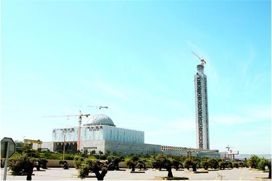 　　图为：11日拍摄的阿尔及利亚大清真寺圆顶祈祷大厅和宣礼塔。(新华社发)  　　随着最后一批混凝土的灌入，由中国建筑工程总公司承建的阿尔及利亚大清真寺宣礼塔11日上午主体结构封顶，其250米的高度刷新了非洲最高建筑的纪录。  　　该项目负责人、中建公司阿尔及利亚分公司总经理周圣介绍，地处阿尔及利亚首都阿尔及尔主城区的大清真寺是阿尔及利亚政府和百姓都非常关注的项目，由阿总统布特弗利卡亲自为其奠基。周圣说，大清真寺可以抵御9级地震，将是中国公司在非洲留下的一个伟大工程。  　　记者了解到，整个项目十分复杂，涉及1600多个欧洲建筑规范、一万多页技术条款、数万张图纸，土建、机电、设计、装修等各领域的标准都与国内不同。中建虽然已在阿尔及利亚扎根30多年，但也是第一次接手如此高标准的项目，过程中遇到不少困难。比如，大清真寺混凝土采用欧洲标准，部分操作温度要控制在30摄氏度以下。为此，中方工程师连夜推算公式，改进配比，同时紧急从国内空运制冰机，最终将混凝土温度降下来。德国监理不得不承认，中建的实力毫不逊于欧洲公司。“中国制造”的建筑也赢得了阿尔及利亚业主的交口称赞。业主代表、阿尔及利亚住房部官员穆萨说，目前在阿尔及利亚建筑市场上几乎看不到欧洲公司的身影，而在这里打拼的中国公司却越来越多，这显示出中国人的能力和实力。  　　因为中国公司在阿尔及利亚修建大量高品质工程，造福当地百姓，阿尔及利亚住房部长特布恩一连用了好几个“感谢”来表达敬意。他表示，这个非洲最高建筑的完成也象征着阿尔及利亚与中国之间的关系达到了新的高度。  　　文章来自：湖北日报